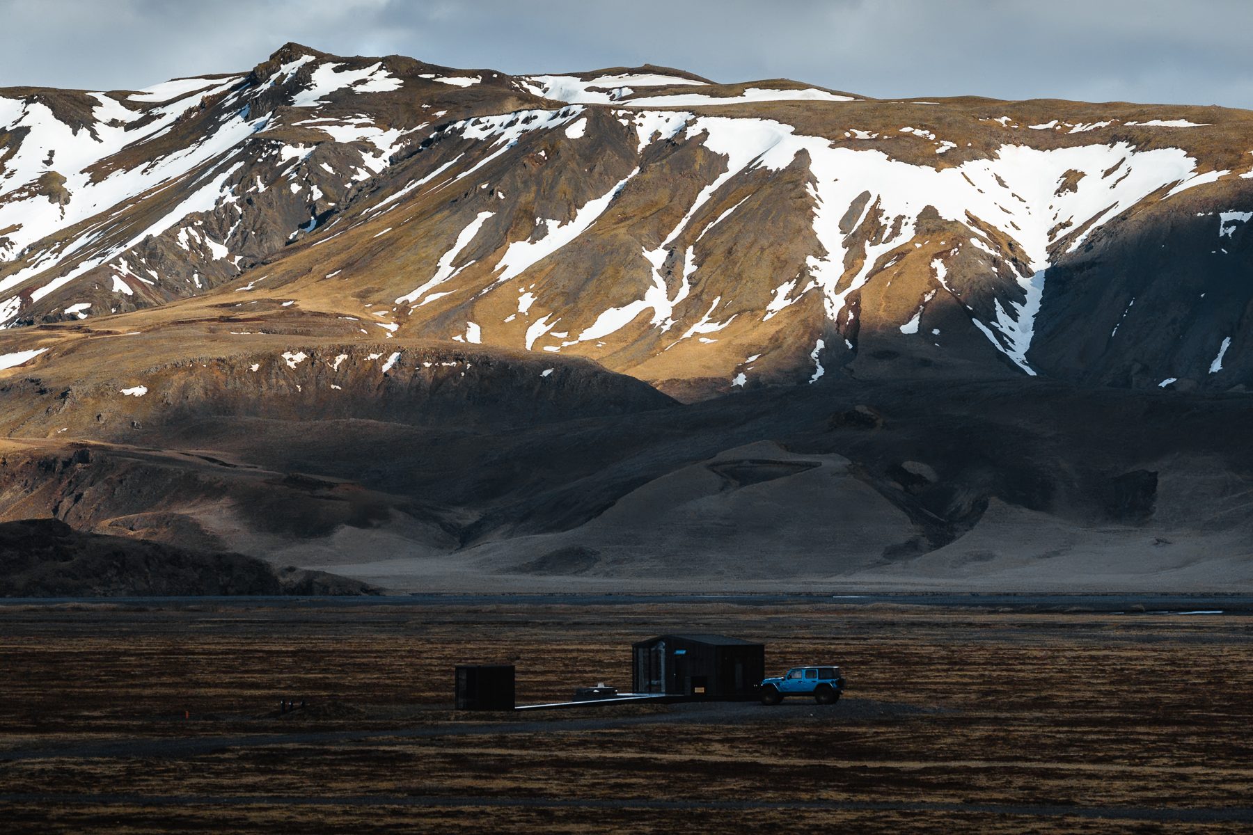 Snow-capped Eyjafjallajokull glacier-volcano behind a luxury lodge in South Iceland