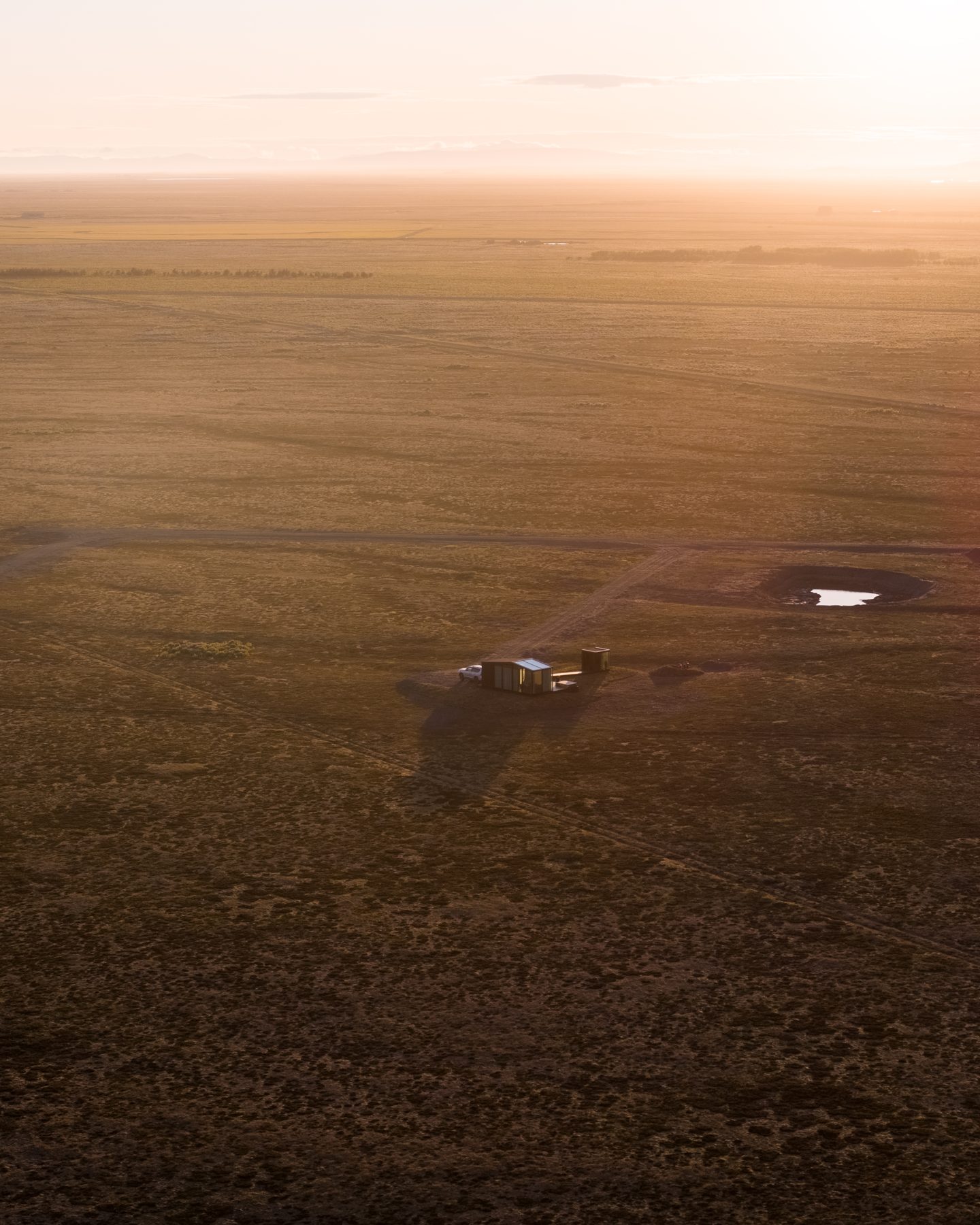 Secluded luxury lodge alone in the vast golden plain of South Iceland at sunset