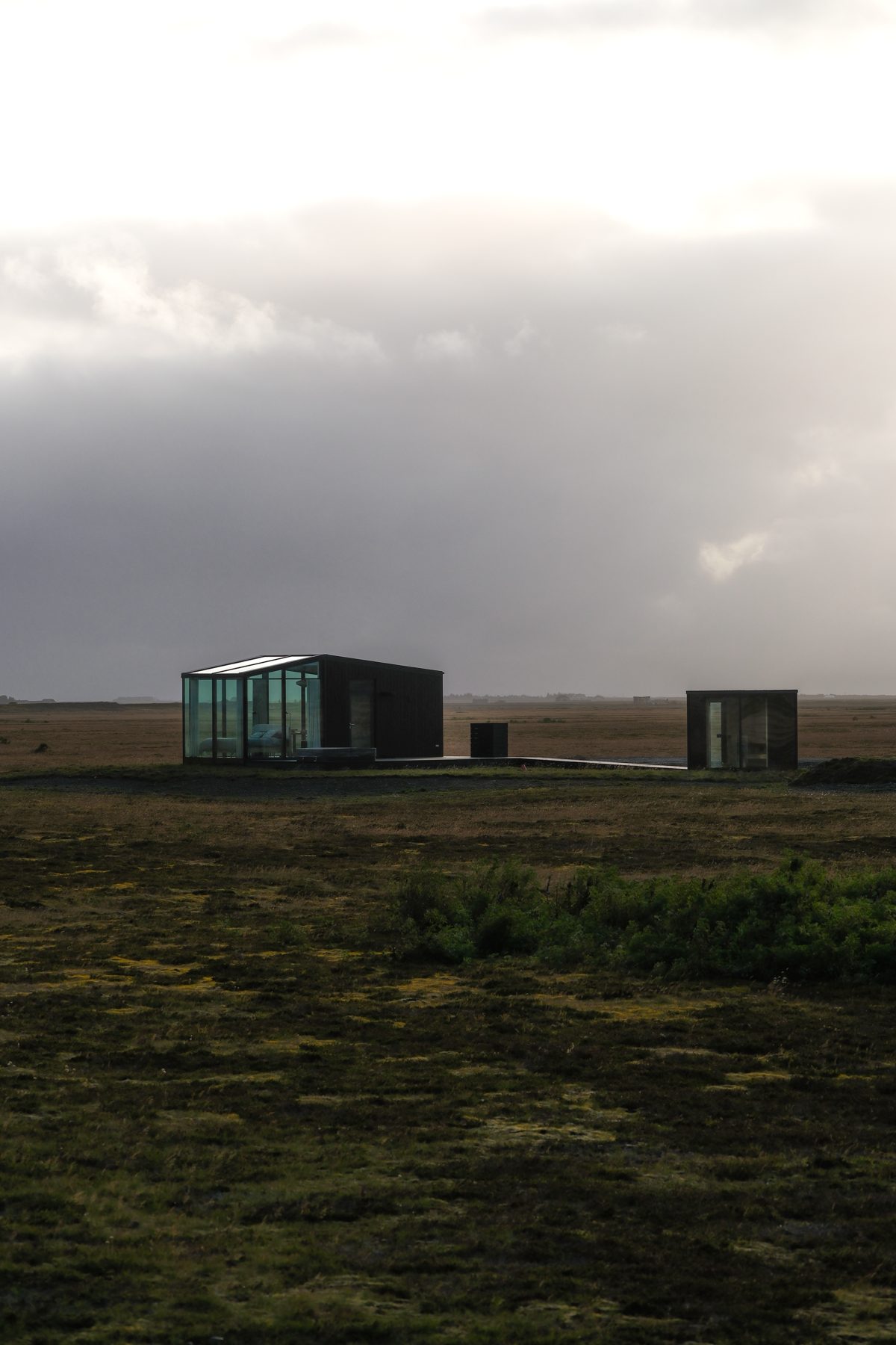 Guest looking through floor-to-ceiling glass at the Icelandic landscape from Harmony lodge