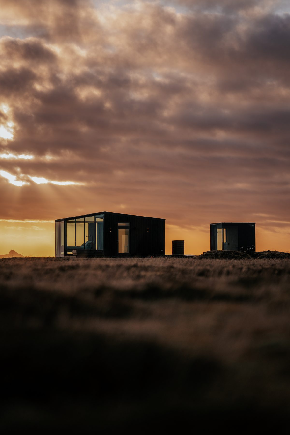 Two Harmony glass lodges at sunset on the South Coast of Iceland, book your luxury retreat