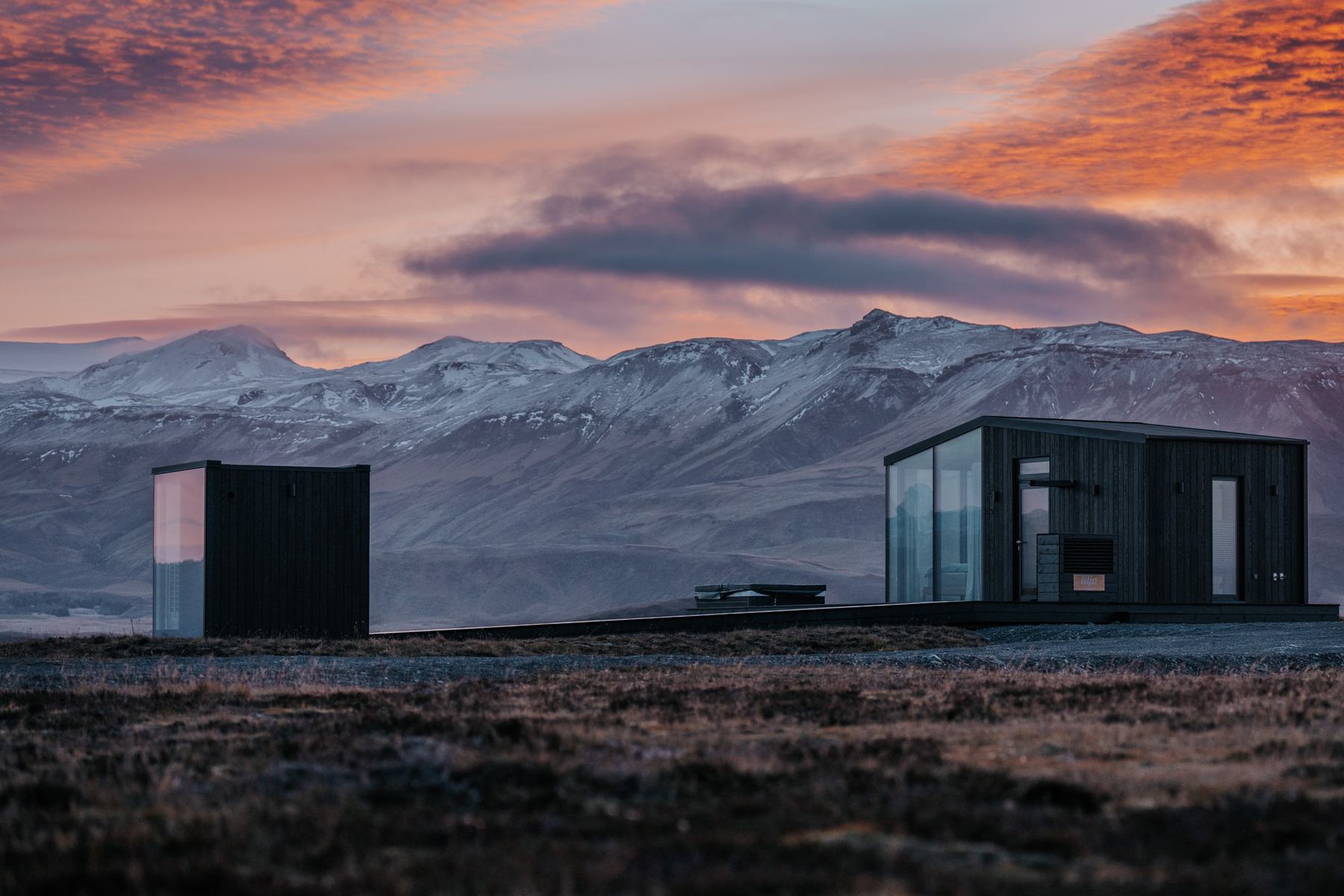 Autumn sunset over snow capped mountains behind the Harmony Seljalandsfoss lodges in South Iceland